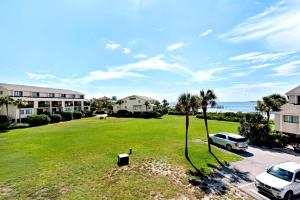 an aerial view of a lawn with palm trees and a building at Santa Rosa Dunes 721 in Pensacola Beach