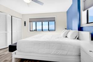 a white bedroom with blue walls and a large bed at Santa Rosa Dunes 721 in Pensacola Beach +44 photos