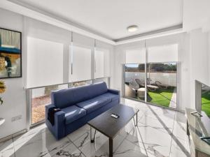 a living room with a blue couch and a table at Alassia Blue Villa in Protaras