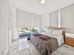 a bedroom with a bed and a large window at Alassia Blue Villa in Protaras