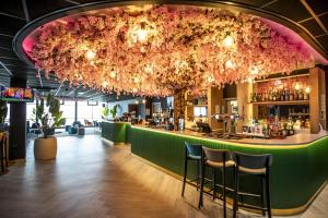 a bar with pink flowers hanging from the ceiling at Best Western Palace Hotel & Casino in Douglas