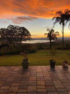 a sunset with two potted plants on a patio at Mon Desir Estate - BR4 in Pietermaritzburg +3 photos