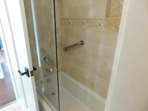 La salle de bains est pourvue d'une douche avec une porte en verre. dans l'établissement Lincoln Green Inn, à Carmel