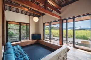 a living room with a couch and a tv at TaaCH Okinawa in Nago