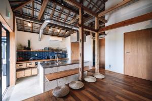 a large kitchen with wooden ceilings and wooden floors at TaaCH Okinawa in Nago