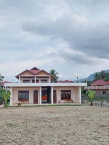 a house in the middle of a field at Toba Sunset in Tuktuk Siadong
