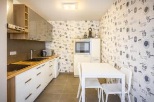 a small kitchen with a white table and a table and chairs at Ferienwohnung Abbey in Müllensiefen