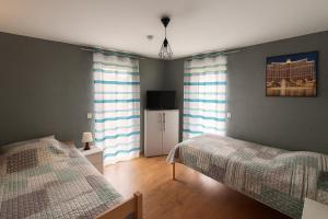 a bedroom with two beds and a television in it at Ferienwohnung Abbey in Müllensiefen