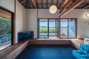 a living room with a blue couch and a tv at TaaCH Okinawa in Nago