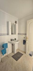 a white bathroom with a sink and a chair at Sunny Hill Apartment in Ciudad Quesada +11 photos