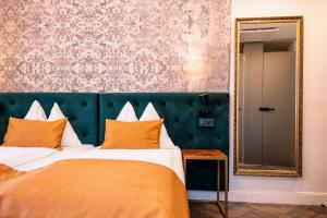 a bedroom with a large bed and a mirror at Hotel Palais26 in Villach