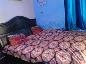 a large bed in a room with a bedspread on it at Vishawkarma Homestay in Gajraula