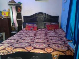 a bedroom with a bed with a quilt on it at Vishawkarma Homestay in Gajraula