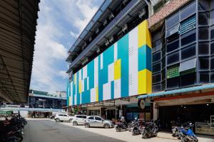 a building with a colorful sign on the side of it at Sans Hotel Sedana Batam in Nagoya