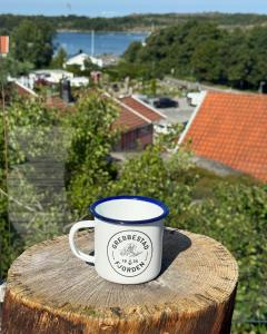 a coffee cup sitting on top of a wooden stump at GrebbestadFjorden glampingpoddar in Grebbestad