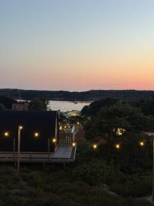a sunset view of a house with a dock at GrebbestadFjorden glampingpoddar in Grebbestad