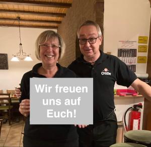 a man and a woman holding a sign at Hotel Landhaus Adensen in Nordstemmen