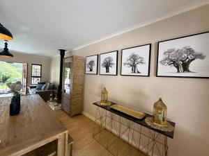 a living room with four drawings of trees on the wall at Hilton Guest House in Hilton