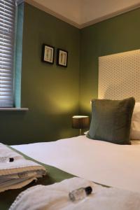 a bedroom with green walls and a bed with a pillow at Crescent Victoria Hotel in Margate