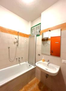 a bathroom with a tub and a sink and a bath tub at Trilocale Prealpi in Margno
