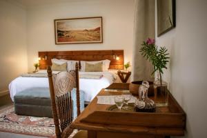 a hotel room with a table and a bed at Kolonie's Tuin in Stellenbosch +55 photos