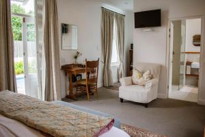 a bedroom with a bed and a chair and a desk at Kolonie's Tuin in Stellenbosch