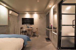 a bedroom with a bed and a table and a tv at MW Hotel in Seoul