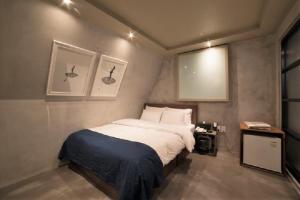 ソウルにあるMWホテルの窓のある部屋にベッドがある寝室