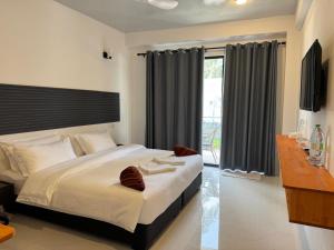 a bedroom with a large bed and a window at Rindhali Thoddoo in Thoddoo