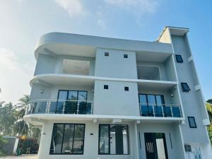 a large white building with a balcony at Rindhali Thoddoo in Thoddoo