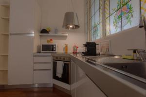 a kitchen with a sink and a counter with a refrigerator at Italianway Easy - Dogana 3 in Milan +5 photos