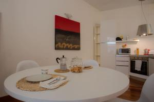 a white kitchen with a white table and chairs at Italianway Easy - Dogana 3 in Milan