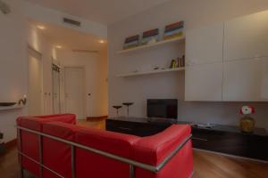 a living room with a red couch and a tv at Italianway Easy - Dogana 3 in Milan