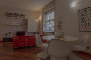a room with a table and chairs and a red couch at Italianway Easy - Dogana 3 in Milan