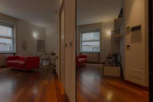 a living room with two red couches and a hallway at Italianway Easy - Dogana 3 in Milan