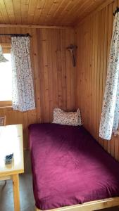 a bedroom with a purple bed in a wooden room at Chalet Valuga in Kaisers