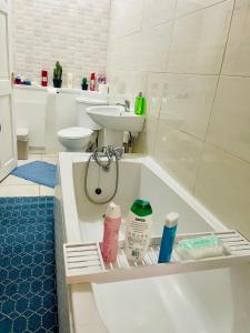 a bathroom with a sink and a bath tub at Cozy Cottage in Liverpool +43 photos