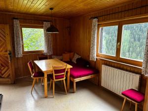 a dining room with a table and chairs and windows at Chalet Valuga in Kaisers