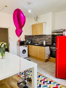 a pink balloon sitting on a table in a kitchen at Cozy Cottage in Liverpool