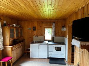 a kitchen with white appliances and a wooden ceiling at Chalet Valuga in Kaisers