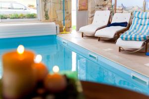 a swimming pool with chairs and a candle next to it at A l'étoile d'or in Batzendorf