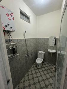a bathroom with a shower and a toilet and a sink at Homestay Anugerah Tumpak sewu in Lumajang +12 photos