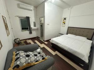 a bedroom with a bed and a chair in it at Homestay Anugerah Tumpak sewu in Lumajang