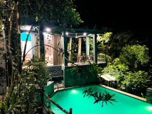 a swimming pool in a garden at night at Niwana Resort in Ratnapura +15 photos