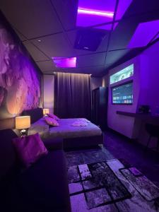 ein Schlafzimmer mit violetter Beleuchtung, einem Bett und einem Sofa in der Unterkunft Opera 235 in Isernia