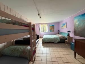 a bedroom with two bunk beds and purple walls at Domaine Bellevie BnB in Vex