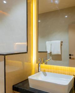a bathroom with a white sink and a mirror at 7EVEN Suites in Lagos