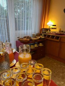 a table with many glasses of orange juice on it at Hotel Landhaus Adensen in Nordstemmen +8 photos