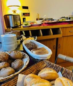 a table with baskets of loaves of bread on it at Hotel Landhaus Adensen in Nordstemmen