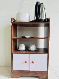 a wooden shelf with dishes and cups on it at Bao An Homestay Mai Chau in Mai Châu